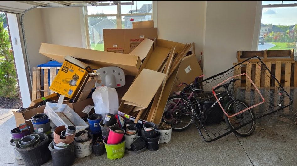 Garage full of boxes, pallets and bikes before junk removal in Howell, MI